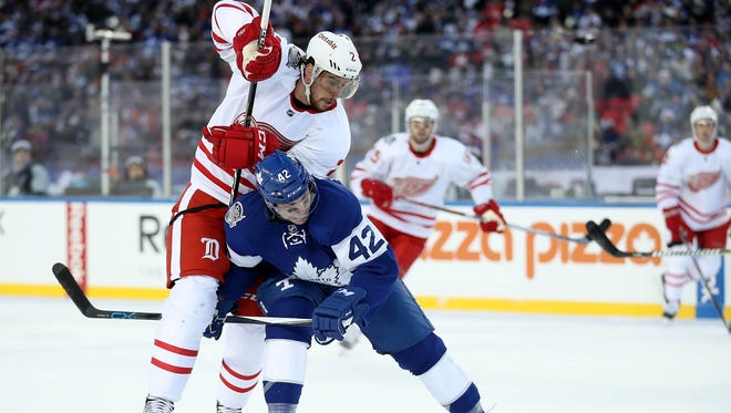 Toronto Maple Leafs center Tyler Bozak (42) fends off Detroit Red Wings defenseman Brendan Smith (2) as they go after the puck during the Centennial Classic ice hockey game at BMO Field. Mandatory Credit: Tom Szczerbowski-USA TODAY Sports