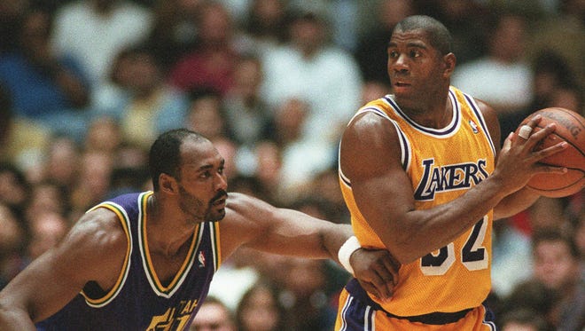 1996: Los Angeles Lakers' Earvin "Magic" Johnson, left, battles with Utah Jazz'  Karl Malone.