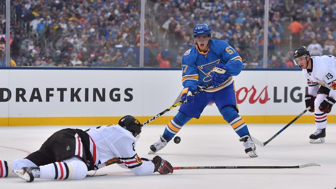 St. Louis Blues left wing David Perron (57) battles for the puck with Chicago Blackhawks defenseman Michal Kempny (6) during the second period in the 2016 Winter Classic.