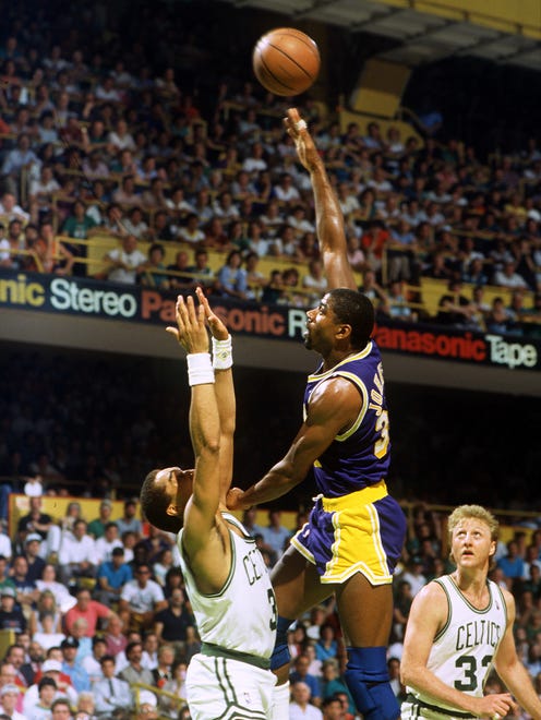 1987: Earvin Magic Johnson shoots over Dennis Johnson as Larry Bird looks on.