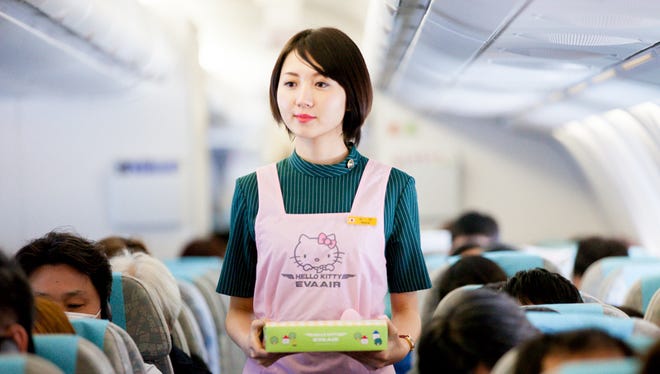 A flight attendant with EVA Airways carriers a kids meal to a waiting passenger on a Hello Kitty-themed flight on Jan. 29, 2015.