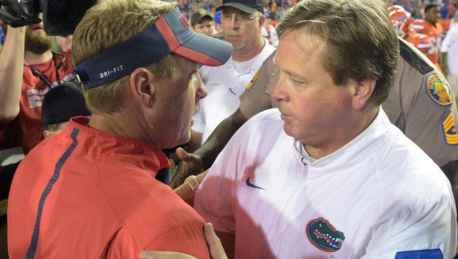 Mississippi head coach Hugh Freeze, left, and Florida head coach Jim McElwain meet on the field after an NCAA college football game Saturday, Oct. 3, 2015, in Gainesville, Fla. Florida won 38-10. (AP Photo/Phelan M. Ebenhack)