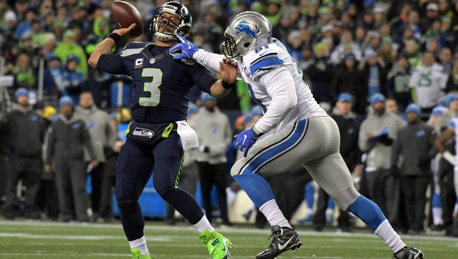 Seattle Seahawks quarterback Russell Wilson (3) moves out to pass against the defense of  Detroit Lions defensive end Kerry Hyder (61) during the first half in the NFC Wild Card playoff football game at CenturyLink Field.