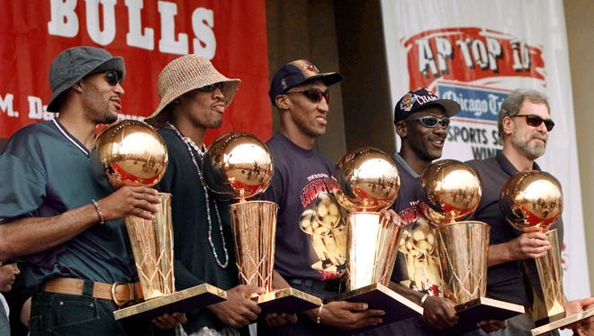 1997: The Bulls hold up five championship trophies.