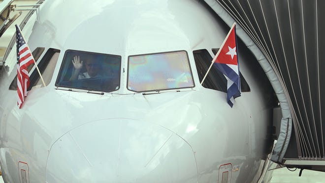 A pilot waves as he prepares to push back from the gate for American Airlines Flight 903, becoming the first commercial flight from Miami to Cuba in 55-years on Sept. 7, 2016 in Miami.