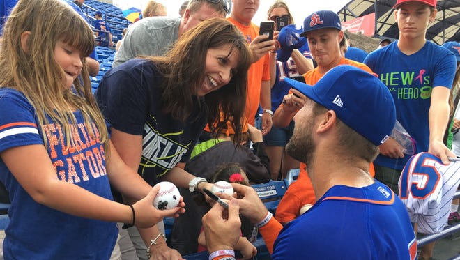 Jennifer Pedrick (center), of Melbourne, gets a baseball autographed by the St. Lucie Mets' Tim Tebow before the start of Wednesday's doubleheader at First Data Field in Port St. Lucie.