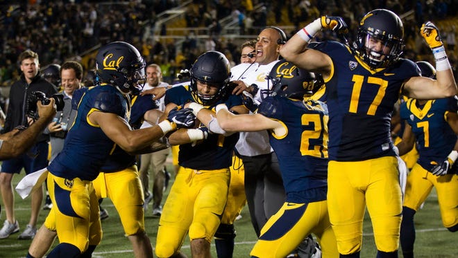 California's Jordan Kunaszyk (59) is surrounded by teammates after getting the game-sealing interception in overtime against Oregon.