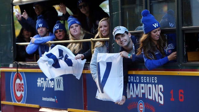 Cubs fans waves flags from a trolley on Michigan Avenue.