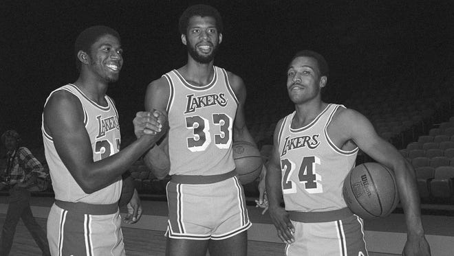 1979: New Los Angeles Laker Earvin "Magic" Johnson, left, former Michigan State champion, greets Lakers veteran Kareem Abdul-Jabbar (33) and Ron Boone (24) during Lakers photo day at the Forum.