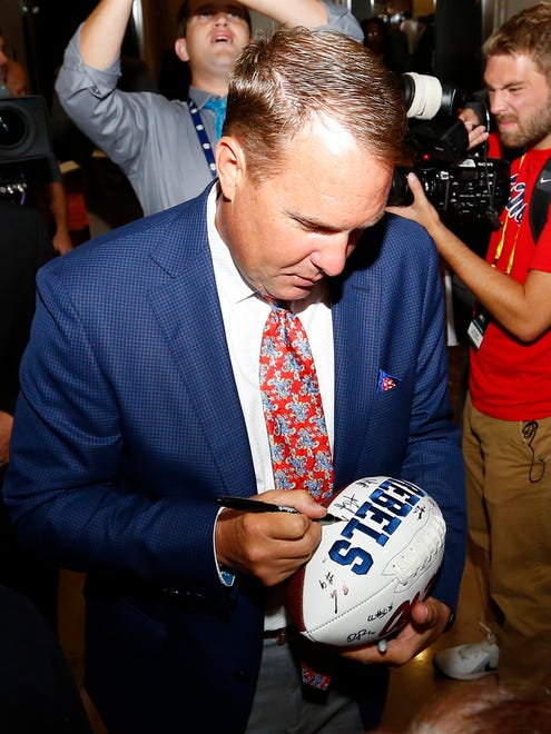 Mississippi NCAA college football coach Hugh Freeze signs autographs for fans during the Southeastern Conference's annual media gathering July 13, 2017 in Hoover, Ala.