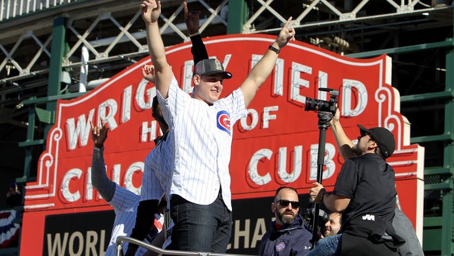 Anthony Rizzo celebrates in front of the Wrigley Field marquee.