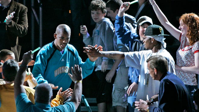2007: New Orleans Hornets guard Chris Paul greets fans as he enters the court.