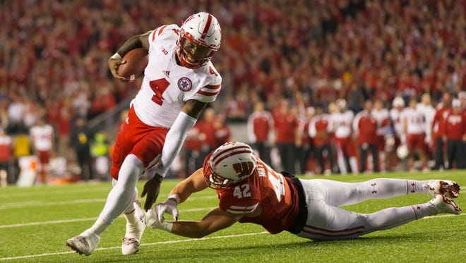 Nebraska quarterback Tommy Armstrong Jr. (4) rushes with the football as Wisconsin linebacker T.J. Watt (42) tries to bring him down.