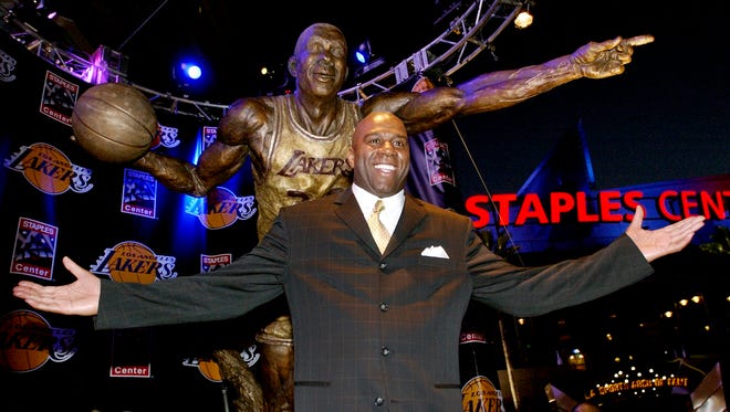 2004: Former Los Angeles Lakers' "Magic" Johnson poses beneath the larger-than-life bronze statue of himself.