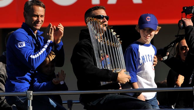 Cubs president Theo Epstein holds the Commissioner's Trophy.