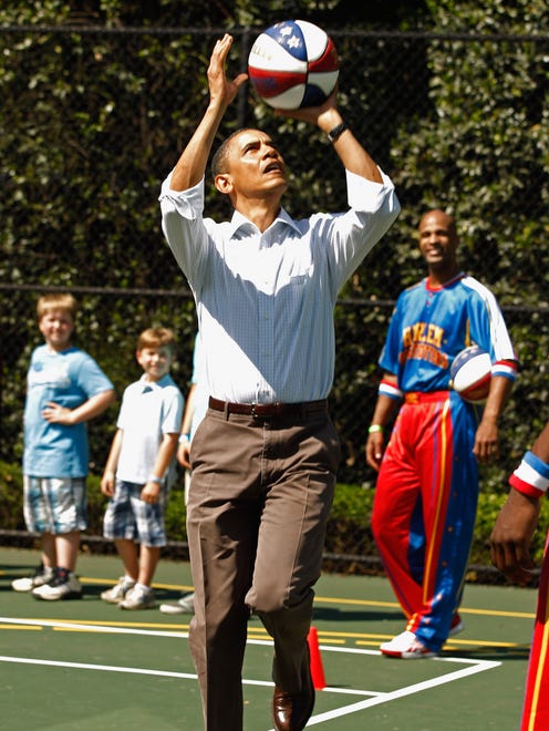 President Barack Obama shoots a basketball while participating in a "Let's Move" clinic with members of the NBA, WNBA and the Harlem Globetrotters during the White House Easter Egg Roll on the South Lawn, April 25, 2011 in Washington, DC.