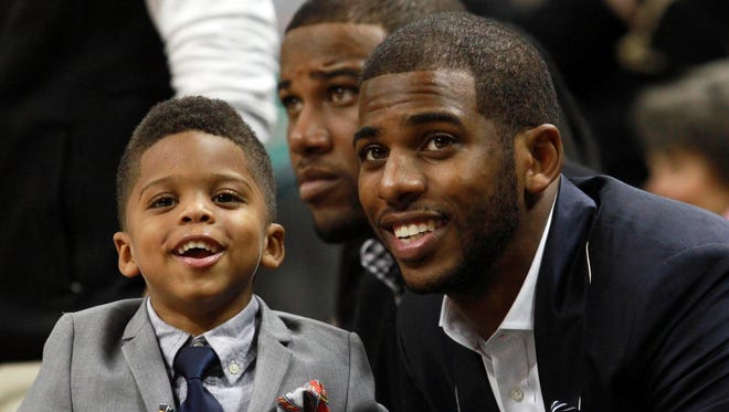 2013: Los Angeles Clippers guard Chris Paul sits with his son Christopher Paul during the second half of the game between the Wake Forest Demon Deacons and the Maryland Terrapins.