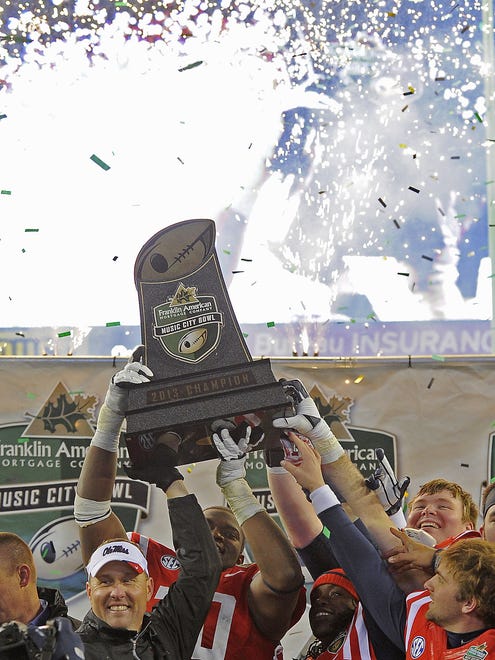 Old Miss head coach Hugh Freeze and his players lift the   Franklin American Mortgage Music City Bowl trophy above their heads after winning against Georgia Tech Dec. 30, 2013, in Nashville, TN.