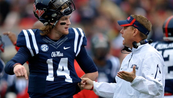 Mississippi quarterback Bo Wallace (14) talks with coach Hugh Freeze during an NCAA college football game against Troy in Oxford, Miss., Saturday, Nov. 16, 2013.