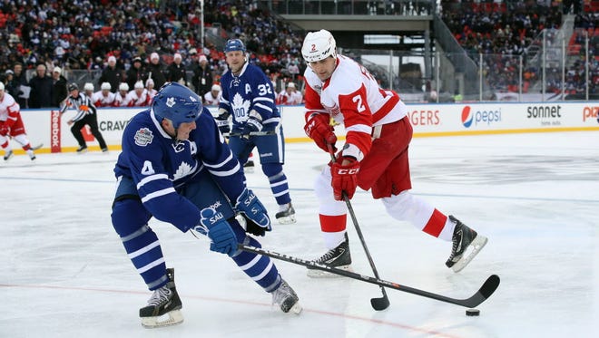 Maple Leafs defenseman Dave Ellett (4) knocks the puck off the stick of the Red Wings' Jiri Fischer (2) during the Centennial Classic Alumni Game.