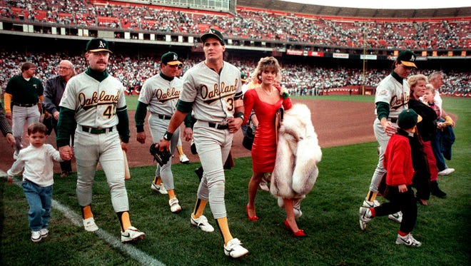 Jose Canseco walks off the field with his wife Ester and other A's players before the start of the 1989 World Series at Candlestick Park in San Francisco. The series was delayed due to the Loma Prieta earthquake.