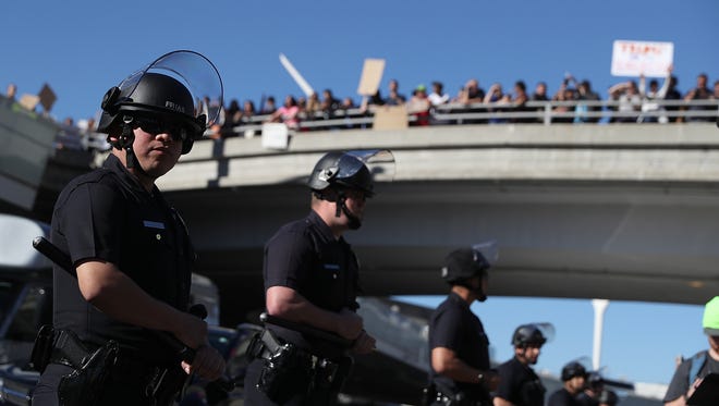 Los Angeles police officers monitor protesters during a demonstration against the immigration travel ban imposed by President Trump at Los Angeles International Airport on January 29, 2017.