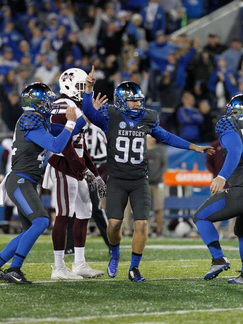 Kentucky kicker Austin MacGinnis (99) celebrates with teammates after hitting the game-winning field goal against Mississippi State.