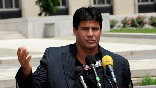 Jose Canseco, who was in and out of legal trouble, talks with reporters after appearing in federal court in Washington in 2010.