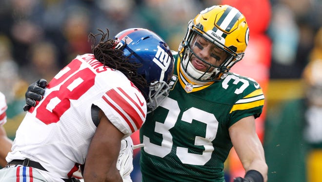 New York Giants running back Paul Perkins (28) is tackled by Green Bay Packers strong safety Micah Hyde (33) during the first quarter in the NFC Wild Card playoff football game at Lambeau Field.