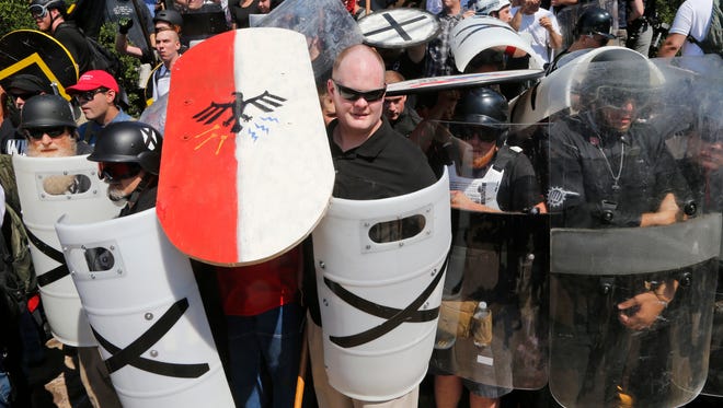 White nationalist demonstrators use shields as they guard the entrance to Lee Park in Charlottesville, Va., Saturday, Aug. 12, 2017.