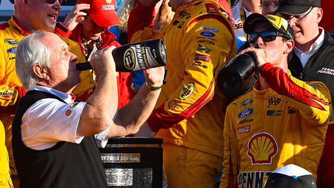 NASCAR Sprint Cup Series driver Joey Logano (right) celebrates with team owner Roger Penske in victory lane after winning the Daytona 500 on Feb. 22, 2015.