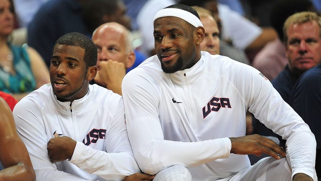 2012: Chris Paul (13) and forward LeBron James (6) watch game action against the Dominican Republic.
