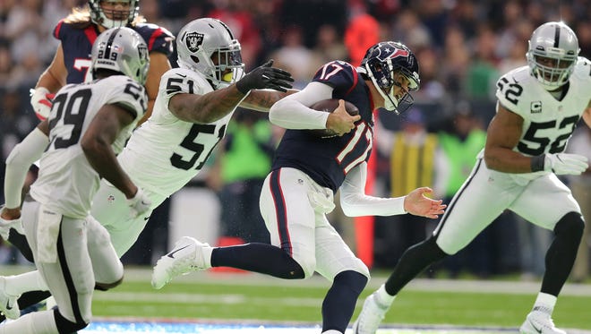Houston Texans quarterback Brock Osweiler (17) scrambles against Oakland Raiders linebacker Bruce Irvin (51) and defensive end Khali Mack (52) in the AFC Wild Card playoff football game at NRG Stadium.