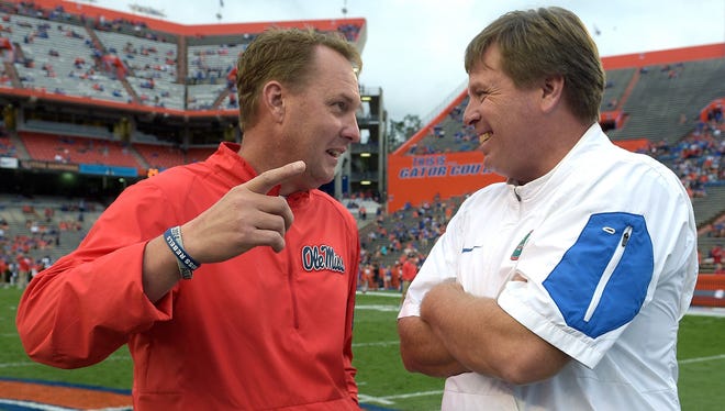 Mississippi head coach Hugh Freeze, left, and Florida head coach Jim McElwain chat on the field before an NCAA college football game Saturday, Oct. 3, 2015, in Gainesville, Fla. (AP Photo/Phelan M. Ebenhack)