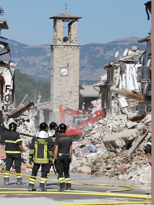 Firefighters stand by rubble in Amatrice, Italy on Aug. 28, 2016, where a 6.1 earthquake struck just after 3:30 a.m., Wednesday. Bulldozers with huge claws pulled down dangerously overhanging ledges Sunday in Italy's quake-devastated town of Amatrice as investigators worked to figure out if negligence or fraud in building codes had added to the quake's high death toll.