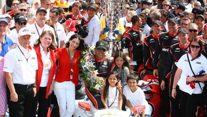 IndyCar Series driver Juan Pablo Montoya celebrates with team owner Roger Penske (left) and his family in victory circle after winning the 2015 Indianapolis 500.
