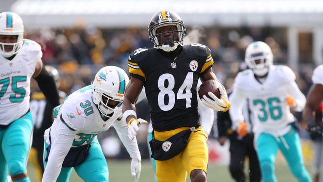 Pittsburgh Steelers wide receiver Antonio Brown (84) carries the ball to score a touchdown against the Miami Dolphins during the first half in the AFC Wild Card playoff football game at Heinz Field.