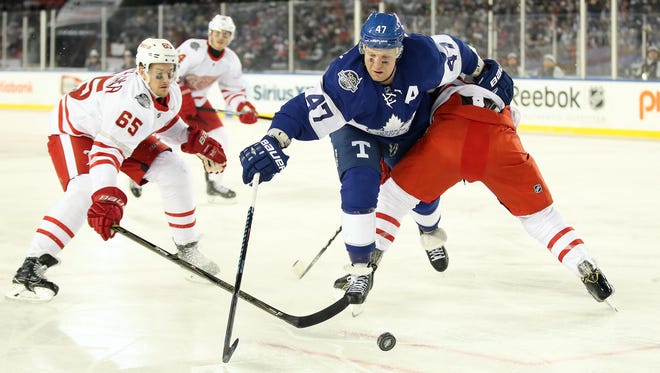 Toronto Maple Leafs center Leo Komarov (47) goes after the puck against Detroit Red Wings defenseman Danny DeKeyser (65) during the Centennial Classic ice hockey game at BMO Field. Mandatory Credit: Tom Szczerbowski-USA TODAY Sports