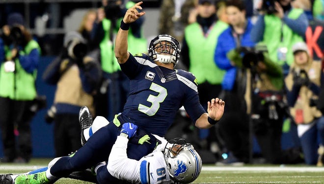 Detroit Lions defensive end Kerry Hyder (61) brings down Seattle Seahawks quarterback Russell Wilson (3) during the first half in the NFC Wild Card playoff football game at CenturyLink Field.