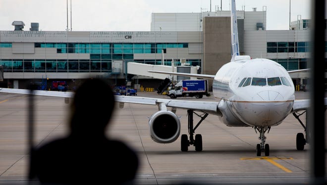 A passenger watches a United Airlines Airbus A320 pull into a gate at Denver International Airport on May 7, 2017.