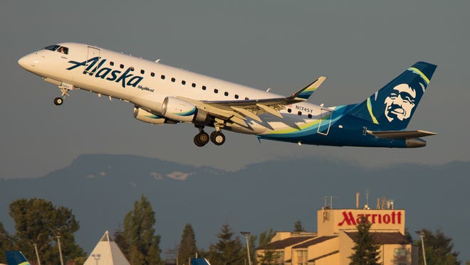 An Alaska Airlines Embraer E170 takes off over company metal at Seattle Tacoma International Airport in May 2017.