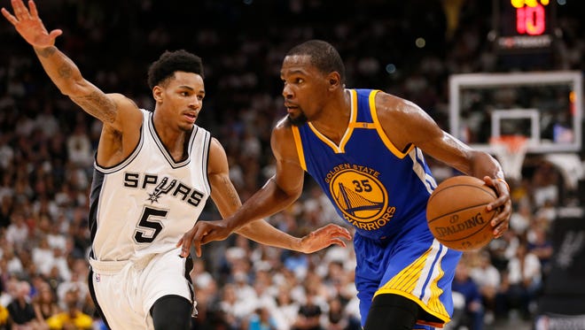 Golden State Warriors small forward Kevin Durant (35) drives to the basket while guarded by San Antonio Spurs point guard Dejounte Murray (5) during the second half in game three of the Western conference finals of the NBA Playoffs.