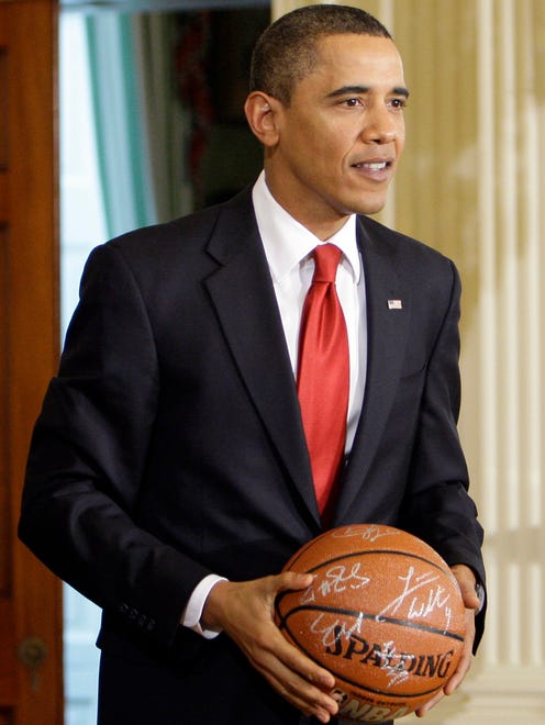President Barack Obama holds a signed basketball given him during a ceremony in the East Room of the White House in Washington, Monday, Jan. 25, 2010.