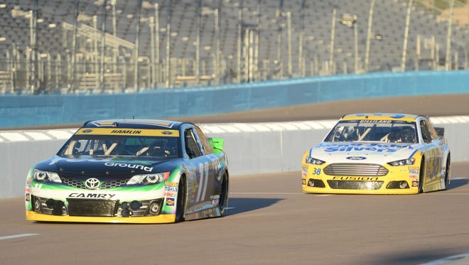 Denny Hamlin (11) and Sprint Cup Series driver David Gilliland (38) during qualifying for the Quicken Loans Race for Heroes 500 at Phoenix International Raceway. Hamlin won the pole.