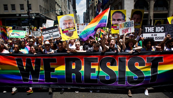 People carry a 'We Resist' banner during the annual New York LGBT Pride March in New York.
