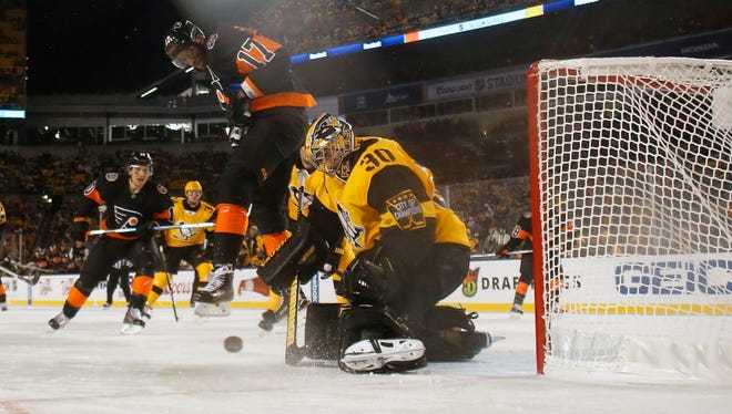 Matt Murray of the Pittsburgh Penguins makes a save as Wayne Simmonds of the Philadelphia Flyers applies a screen during the third period of the game at Heinz Field in Pittsburgh. Pittsburgh defeated Philadelphia, 4-2.