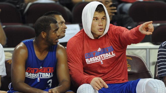 2011: Los Angeles Clippers guard Chris Paul (3) and forward Blake Griffin (32) talk on the bench.
