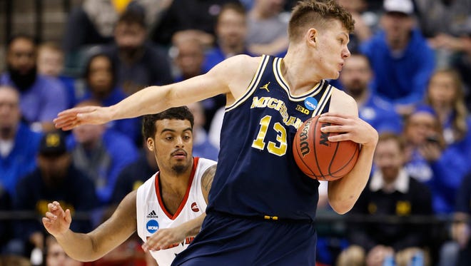 Michigan forward Moritz Wagner spins away from Louisville guard Quentin Snider during their second round NCAA tournament game.