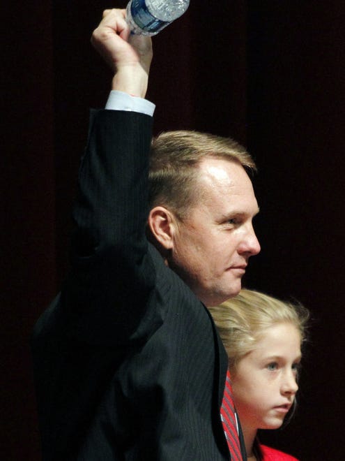 New Mississippi football coach Hugh Freeze gestures to supporters as he and daughter Ragan, 13, leave after he was introduced, Monday, Dec. 5, 2011, in Oxford, Miss. Freeze replaces four-year coach Houston Nutt.