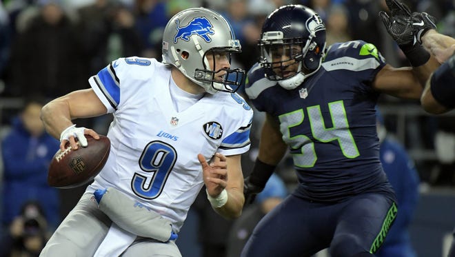 Detroit Lions quarterback Matthew Stafford (9) moves out to pass while being pressured by Seattle Seahawks middle linebacker Bobby Wagner (54) during the first half in the NFC Wild Card playoff football game at CenturyLink Field.